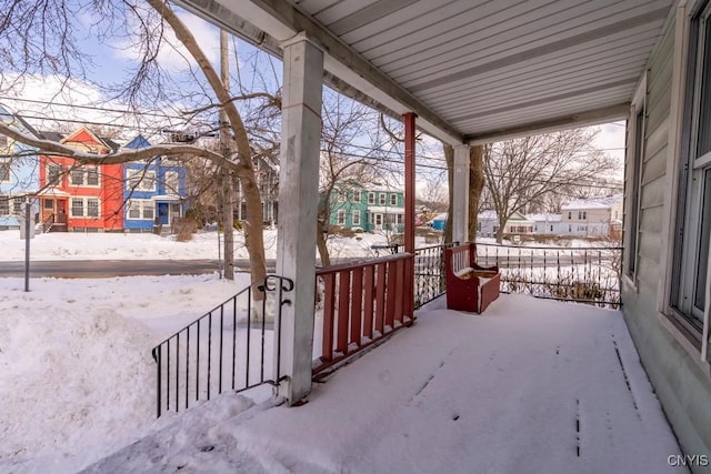 snow covered patio with a residential view