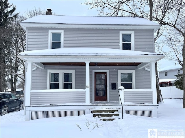 view of front of home with a chimney and a porch