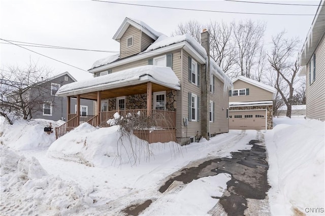 traditional style home with a porch, a chimney, and an attached garage