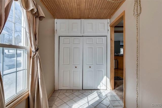 interior space with a closet, wooden ceiling, and light tile patterned floors