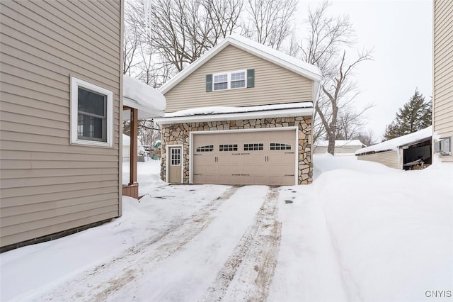 snow covered property featuring stone siding