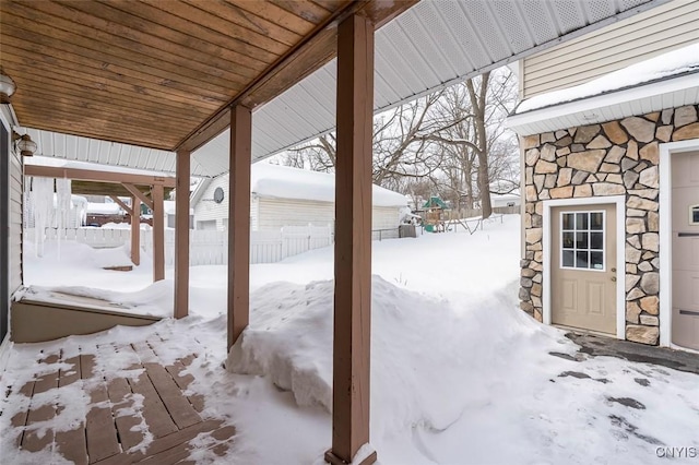 snow covered patio featuring fence