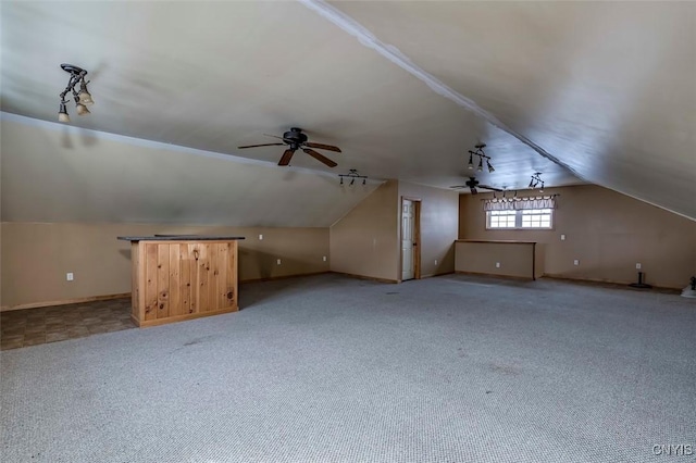 additional living space featuring baseboards, vaulted ceiling, a ceiling fan, and light colored carpet