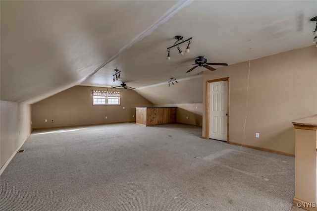 additional living space featuring carpet flooring, baseboards, a ceiling fan, and vaulted ceiling