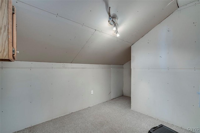bonus room with carpet flooring and vaulted ceiling
