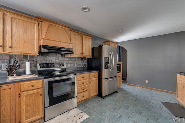 kitchen with dark countertops, backsplash, appliances with stainless steel finishes, under cabinet range hood, and baseboards