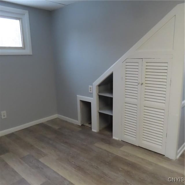 unfurnished bedroom with a closet, baseboards, and wood finished floors