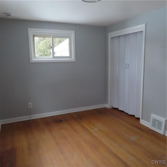 unfurnished bedroom featuring light wood finished floors, a closet, visible vents, and baseboards