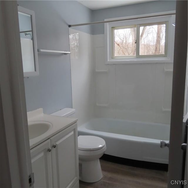 full bathroom featuring toilet, shower / bath combination, wood finished floors, and vanity