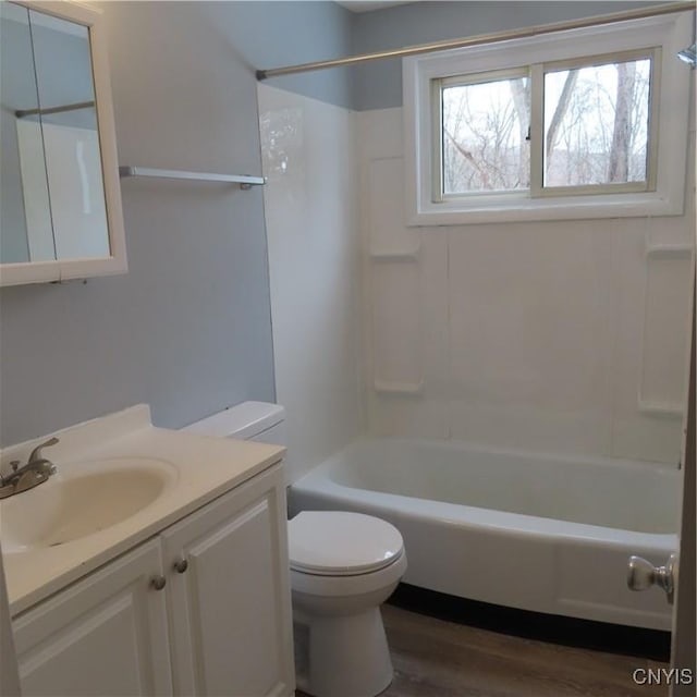 full bathroom with toilet,  shower combination, wood finished floors, and vanity