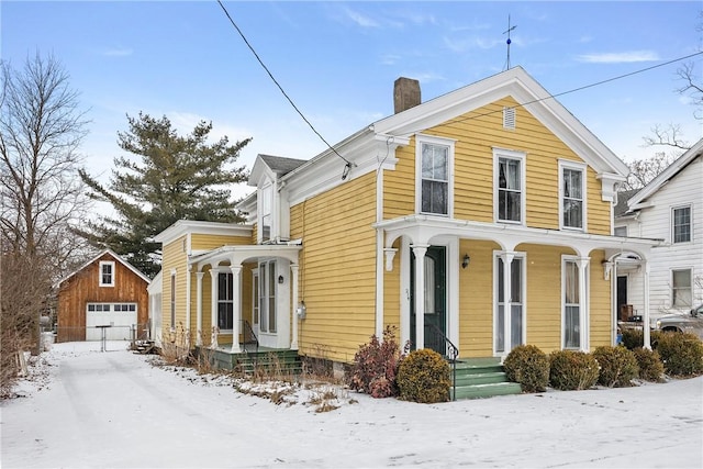 view of front of home with an outbuilding, a detached garage, and a chimney