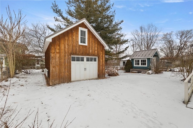 snow covered garage with a detached garage