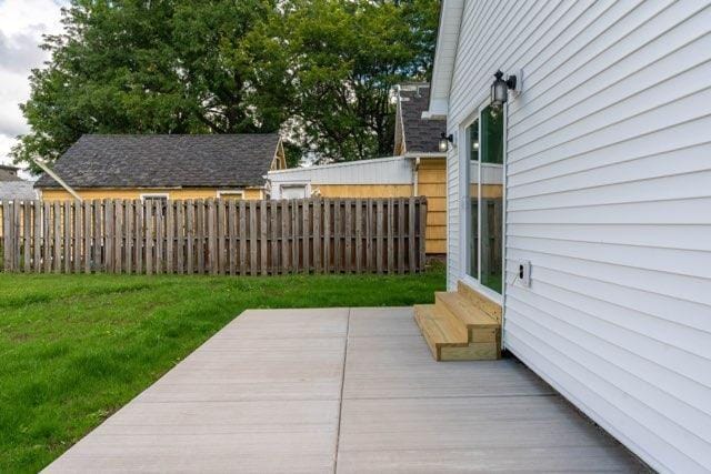 wooden terrace featuring entry steps, a lawn, and fence