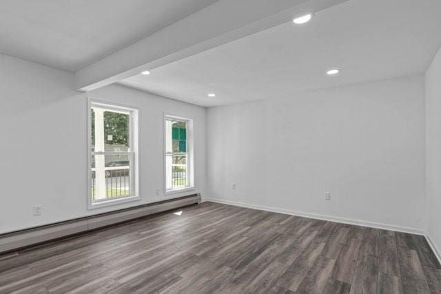 empty room featuring baseboards, dark wood-style flooring, a baseboard radiator, and recessed lighting