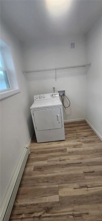 washroom with laundry area, visible vents, a baseboard radiator, washer / clothes dryer, and wood finished floors