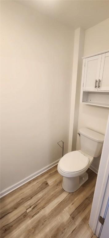 bathroom featuring toilet, baseboards, and wood finished floors