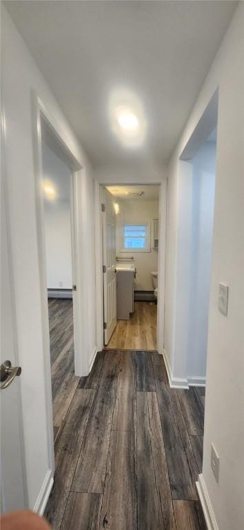 corridor with baseboards and dark wood finished floors