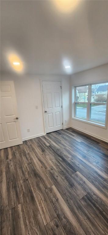 empty room featuring dark wood-type flooring and baseboards