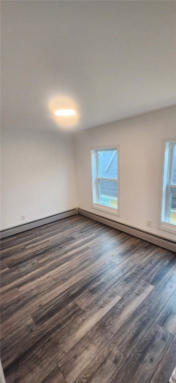 unfurnished room with a baseboard heating unit and dark wood-style floors