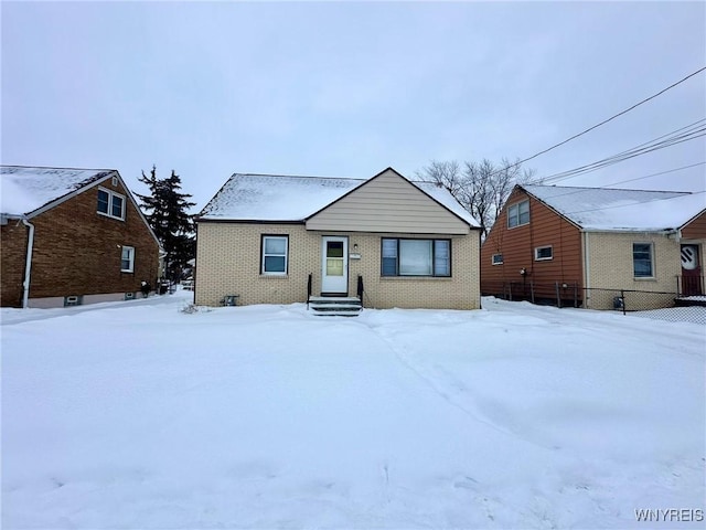 view of front of home featuring brick siding and fence