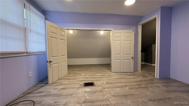 corridor with visible vents and wood finished floors