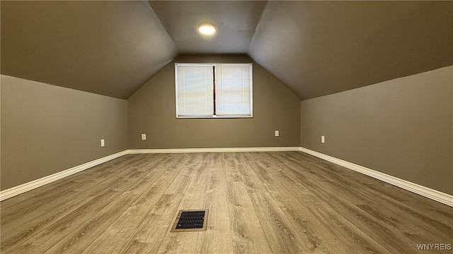 bonus room with visible vents, vaulted ceiling, baseboards, and wood finished floors