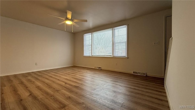 unfurnished room featuring ceiling fan, visible vents, and wood finished floors