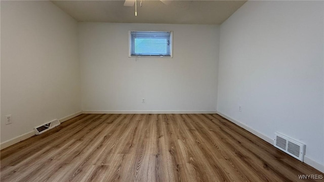 unfurnished room with baseboards, visible vents, and light wood finished floors