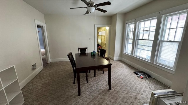 carpeted dining area featuring baseboards, visible vents, and ceiling fan