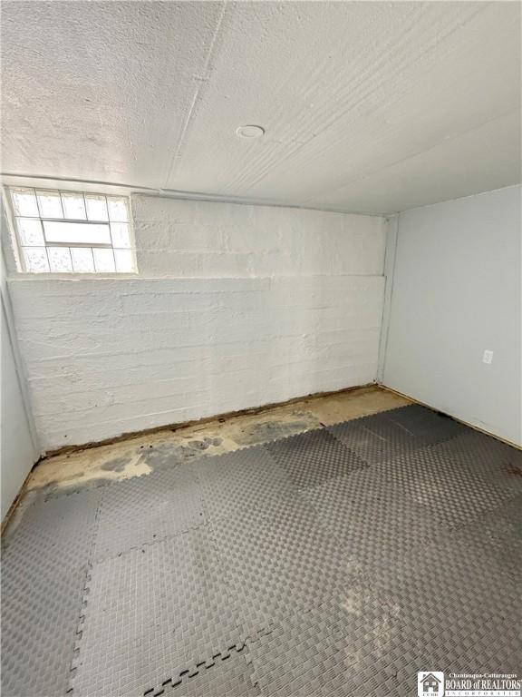 interior space with concrete block wall and a textured ceiling