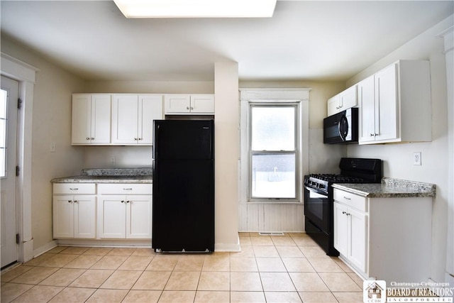 kitchen featuring black appliances, stone counters, and white cabinetry