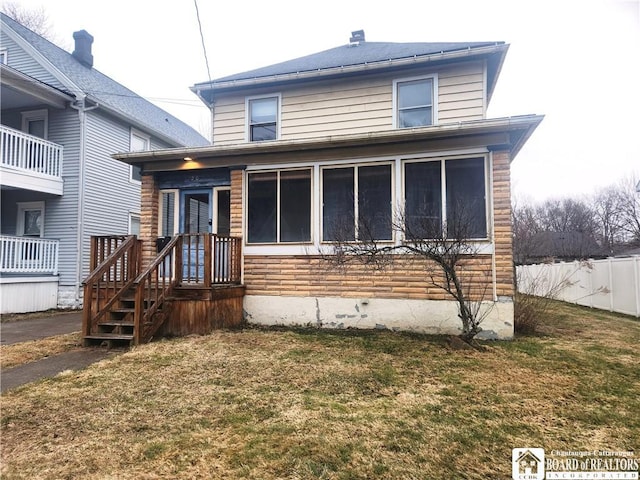 american foursquare style home with a front yard and fence