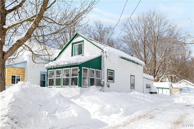 view of front of home with a sunroom and a detached garage