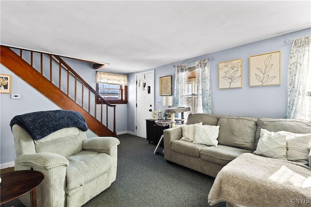 living room with dark carpet, baseboards, and stairs