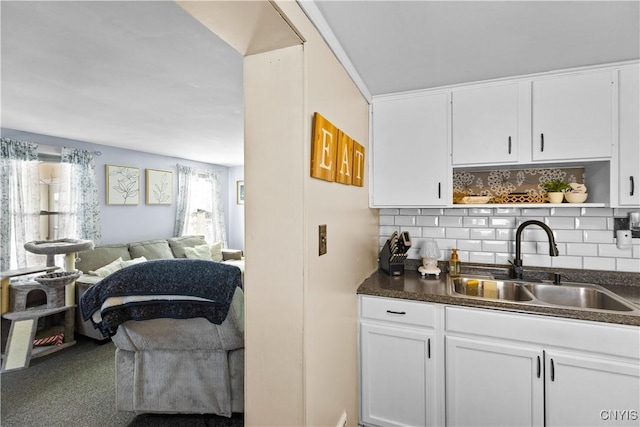 interior space featuring backsplash, carpet flooring, and a sink