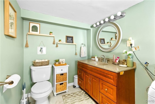 bathroom with baseboards, vanity, and toilet