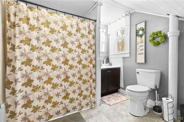 bathroom with lofted ceiling, toilet, and vanity