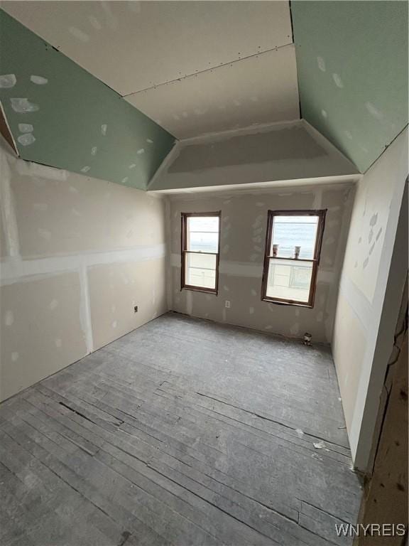 unfurnished room featuring vaulted ceiling