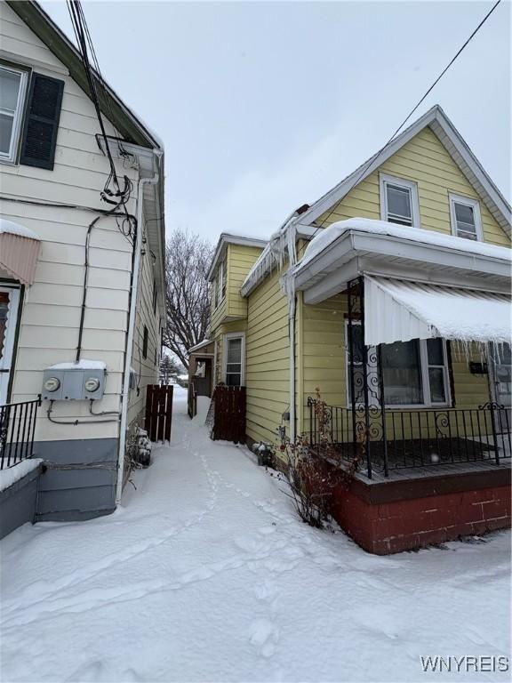 view of snowy exterior featuring covered porch