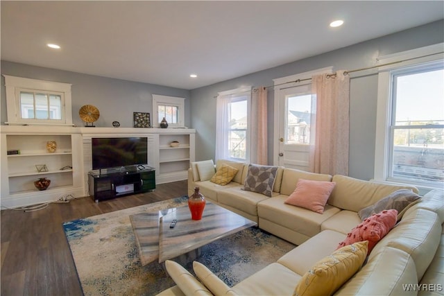 living room with dark wood finished floors and recessed lighting