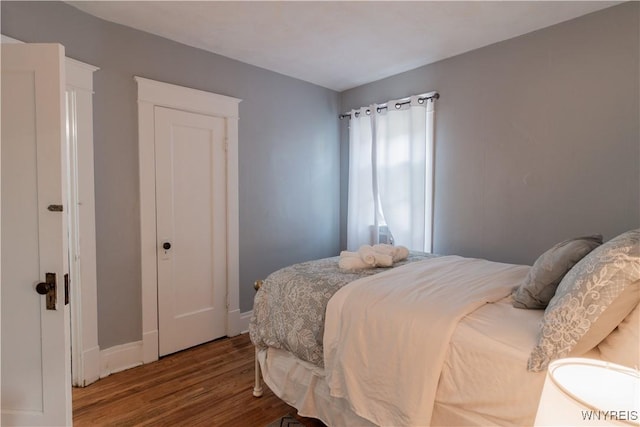 bedroom with wood finished floors and baseboards