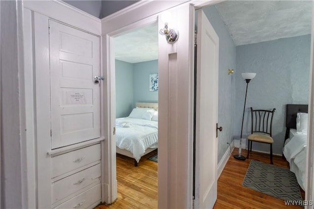 bedroom featuring baseboards and wood finished floors