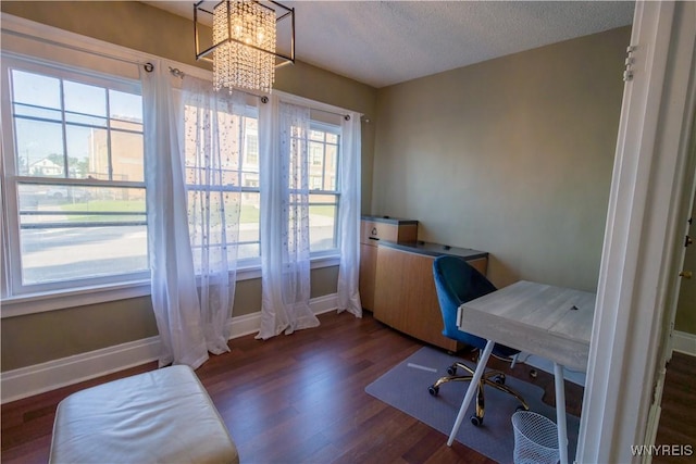 office area with a textured ceiling, dark wood-type flooring, a notable chandelier, and baseboards