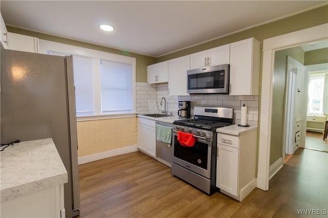 kitchen featuring light countertops, appliances with stainless steel finishes, a sink, and white cabinetry