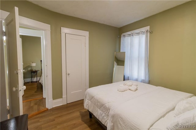 bedroom featuring wood finished floors and baseboards