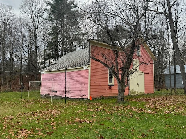 view of home's exterior with metal roof and a lawn