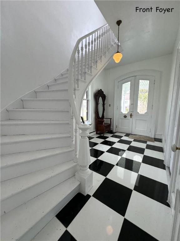 entrance foyer featuring stairs, french doors, and tile patterned floors