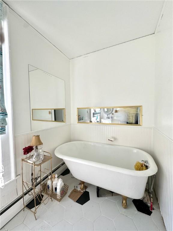 full bathroom featuring a freestanding tub and a wainscoted wall