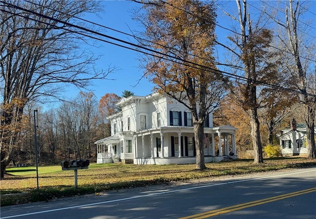 italianate home with a porch and a front lawn