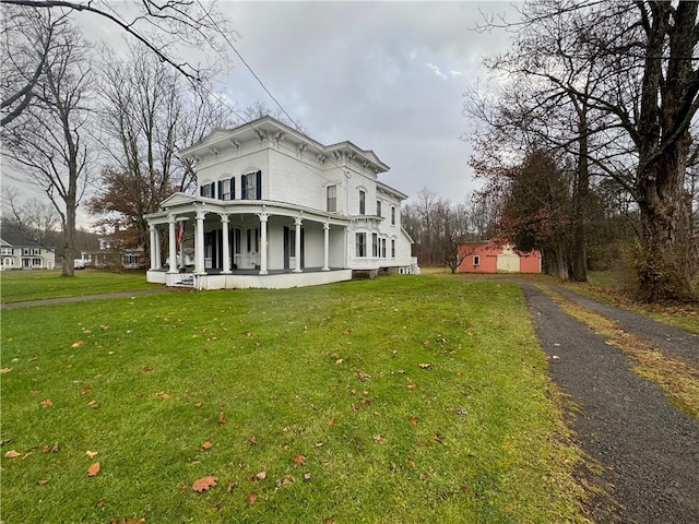 view of front of home with a porch, a front yard, and aphalt driveway